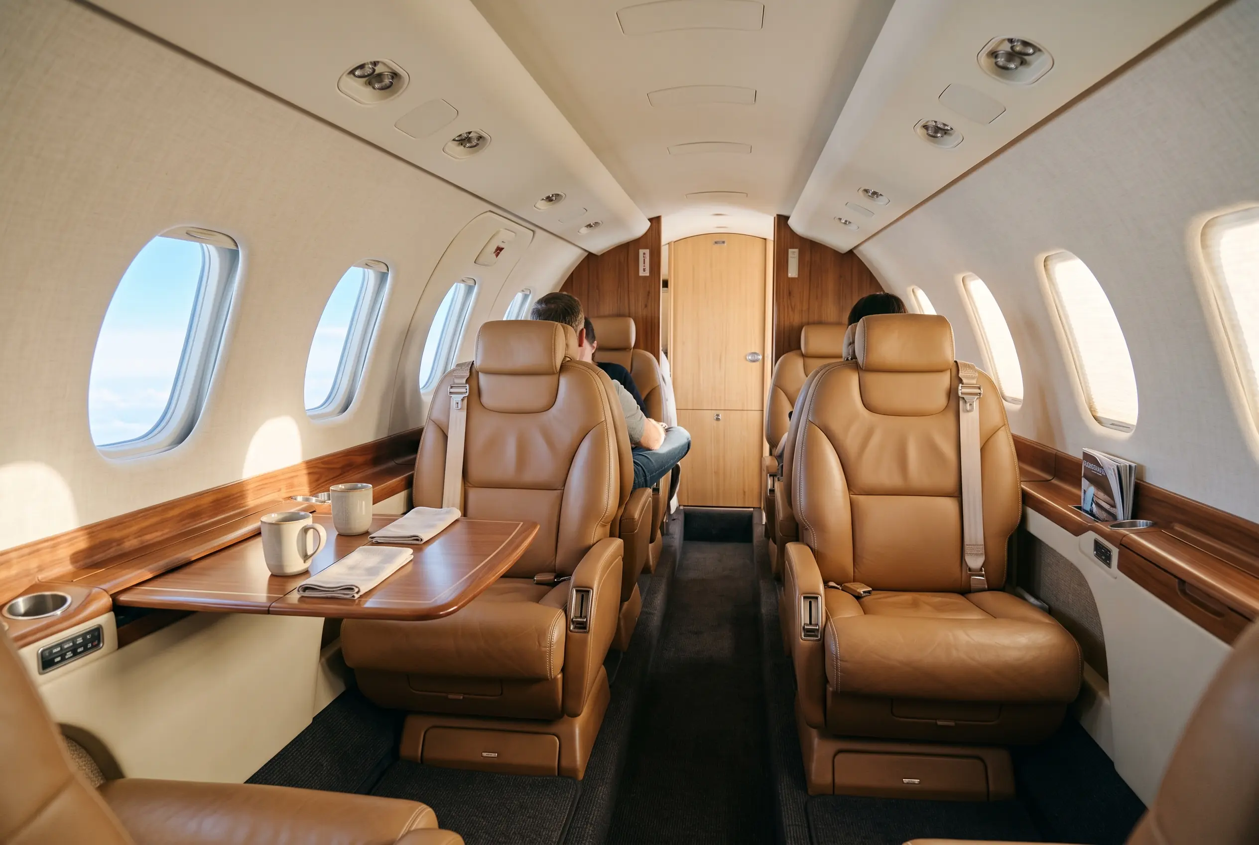 Citation Excel cabin bathed in morning light, tan leather club seats and a dropped centre aisle you can walk upright
