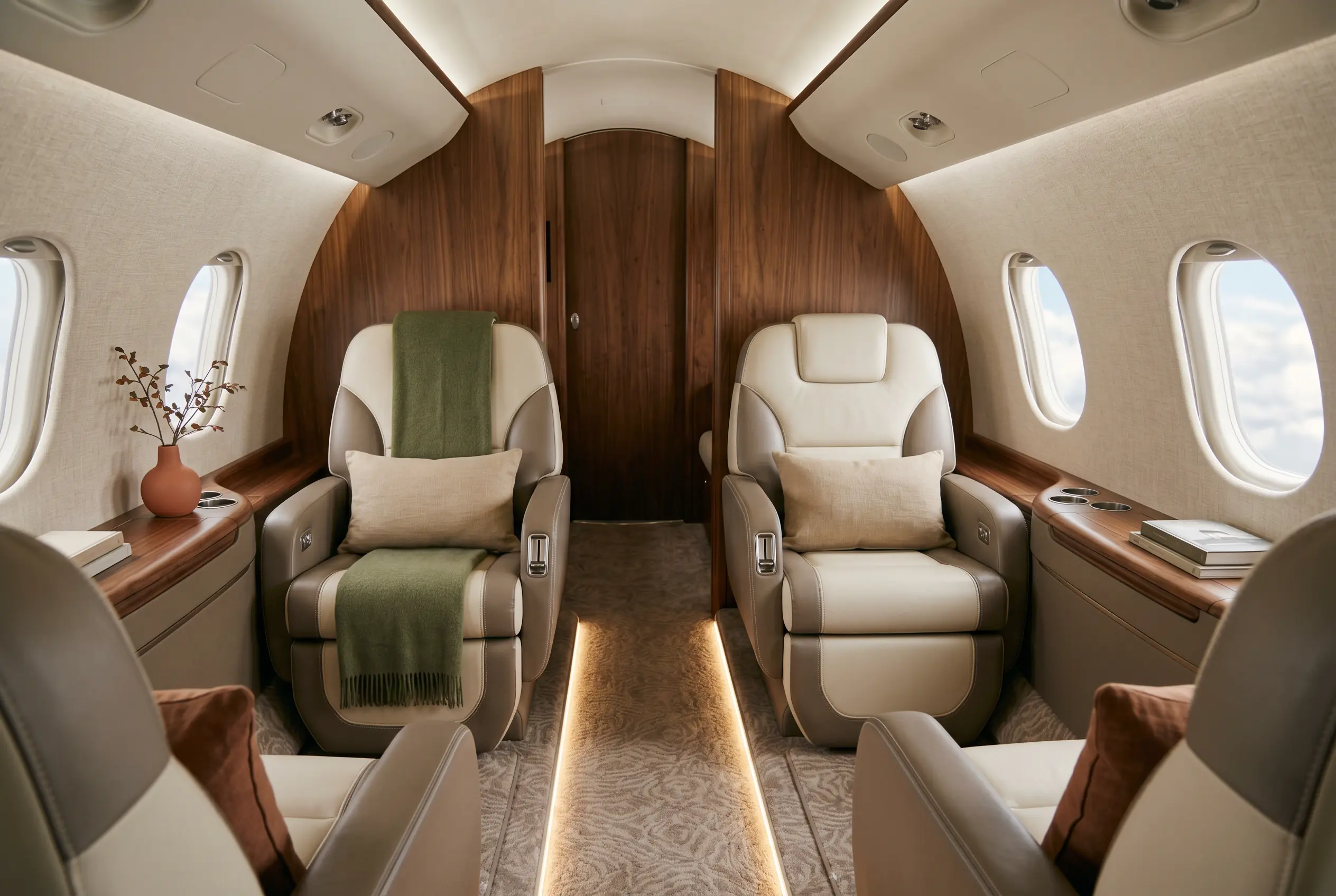 Elegant oval jet cabin with six club seats in two-tone leather, warm light along the aisle